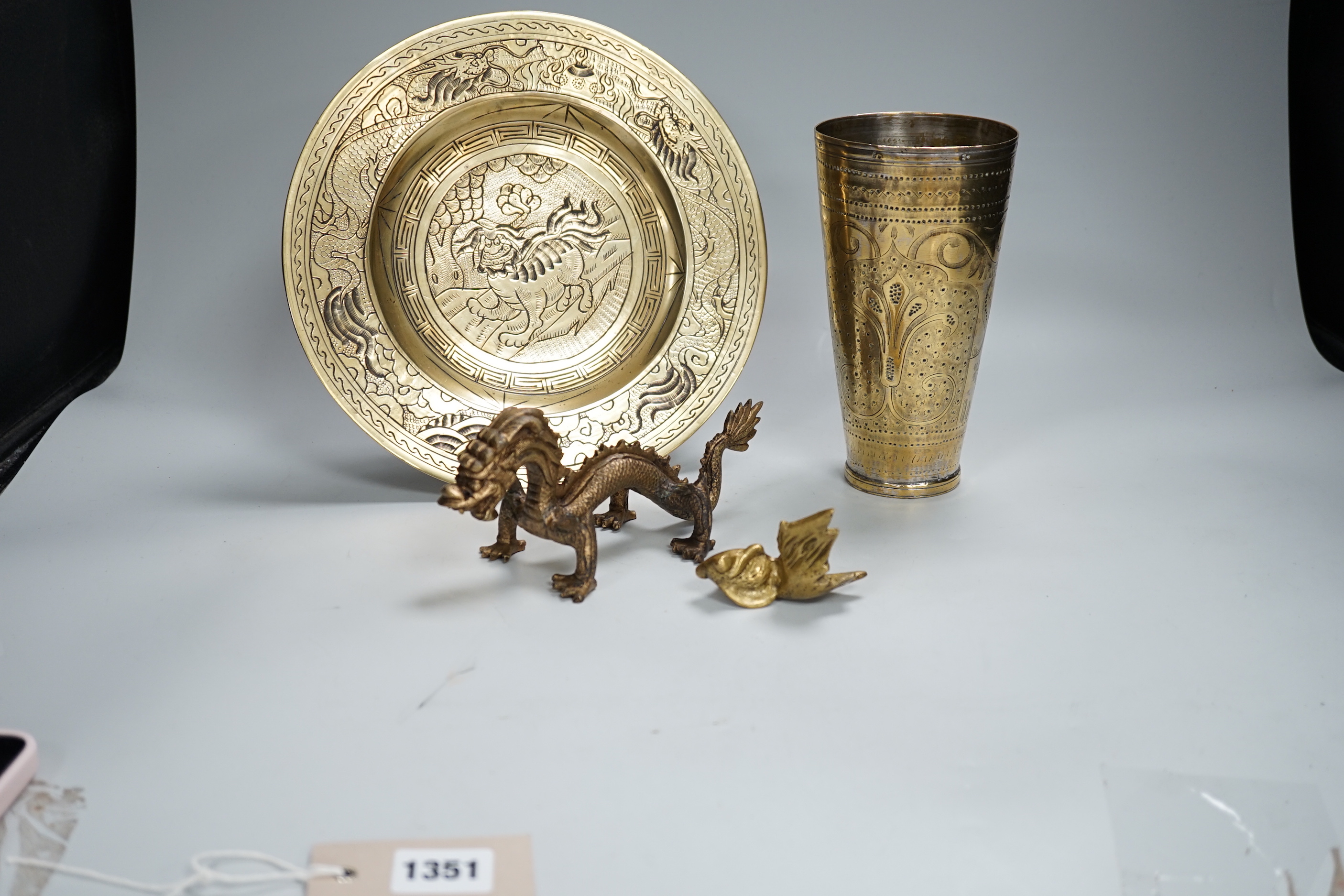 A Chinese engraved brass plate, large engraved beaker, koi fish and a dragon, the largest 24cm in diameter